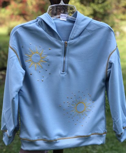 The finished sky blue sweater on a hanger.