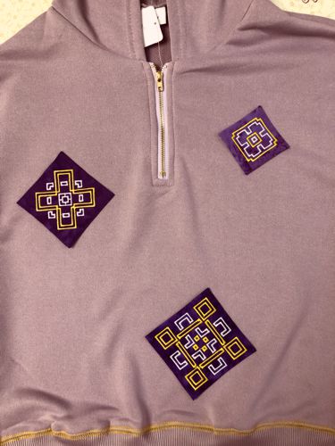 Stitch-outs positioned on the front of the sweat shirt.