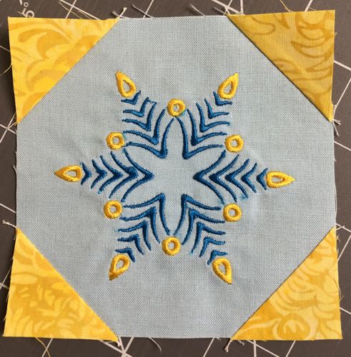 All 4 corners of the embroidered square with yellow corners.