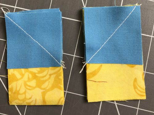 Yellow strips and blue squares stitched together by diagonal.