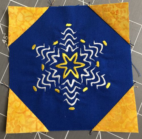 All 4 corners of the embroidered square with yellow corners.