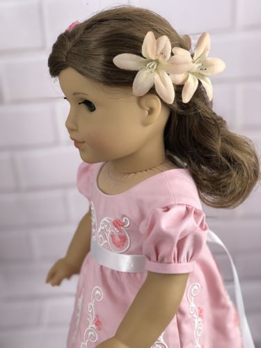 A doll in the Regency style dress with embroidery.