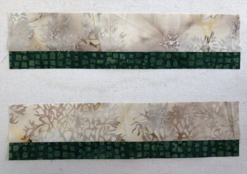 Sew the 2 green 1" x 10 1/2" strips to 2 light-colored 2" x 10 1/2" strips.