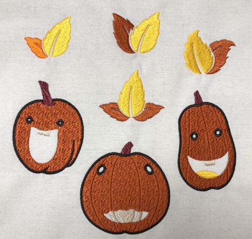 Embroidery of Jack-o-Lanterns and leaves on white canvas