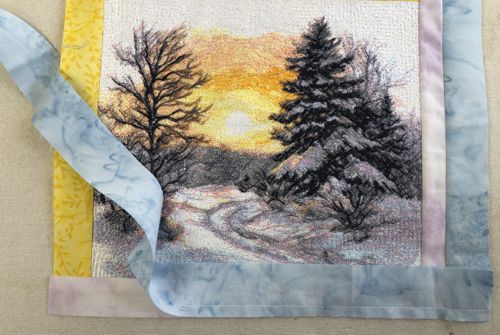 A blue strip attached to the bottom of the working piece, the stitching stops 2" before the left edge.