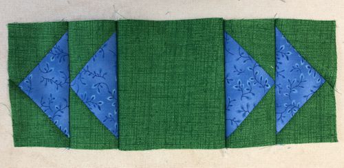 Sew the flying geese blocks to the central green square.