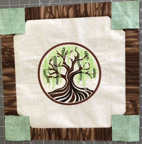 Green squares stitched in the corners of the working piece.